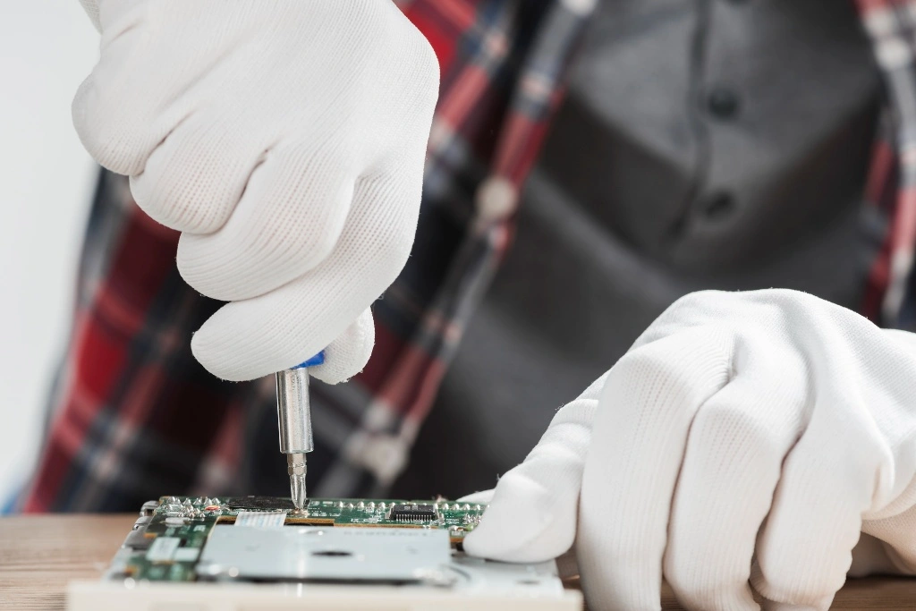 An electronics engineer testing a circuit board with multimeter probes, specializing in high-performance FPGA system architecture and hardware debugging for small businesses.