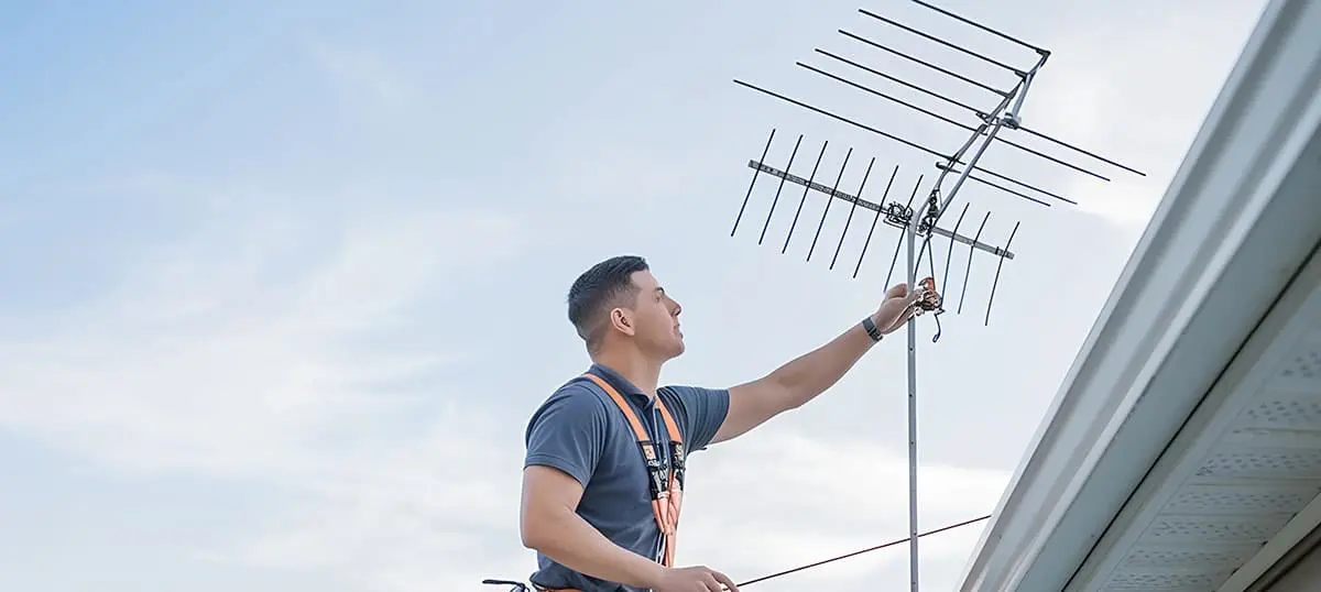Technician installing a complex multi-element array, highlighting the work of an Antenna Design Consultant.